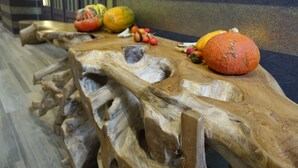 A wooden table with a unique, natural design, featuring a variety of fruits and vegetables. - Hôtel du Parc (Ath)