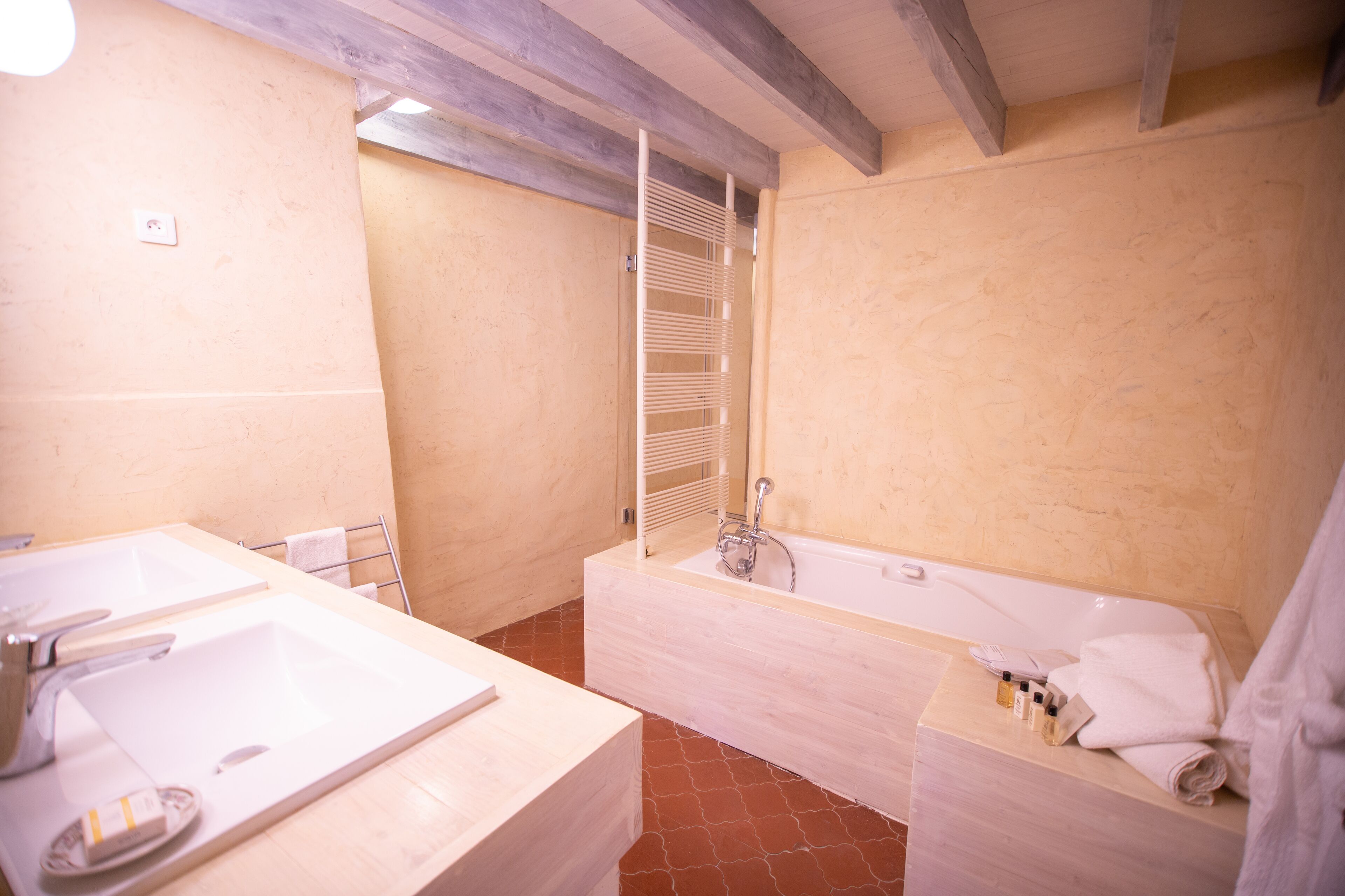Un bagno con una vasca da bagno grande, due lavandini e un portasciugamani.