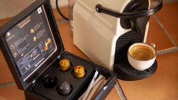Una máquina de café Nespresso con una taza de café sobre una bandeja negra.