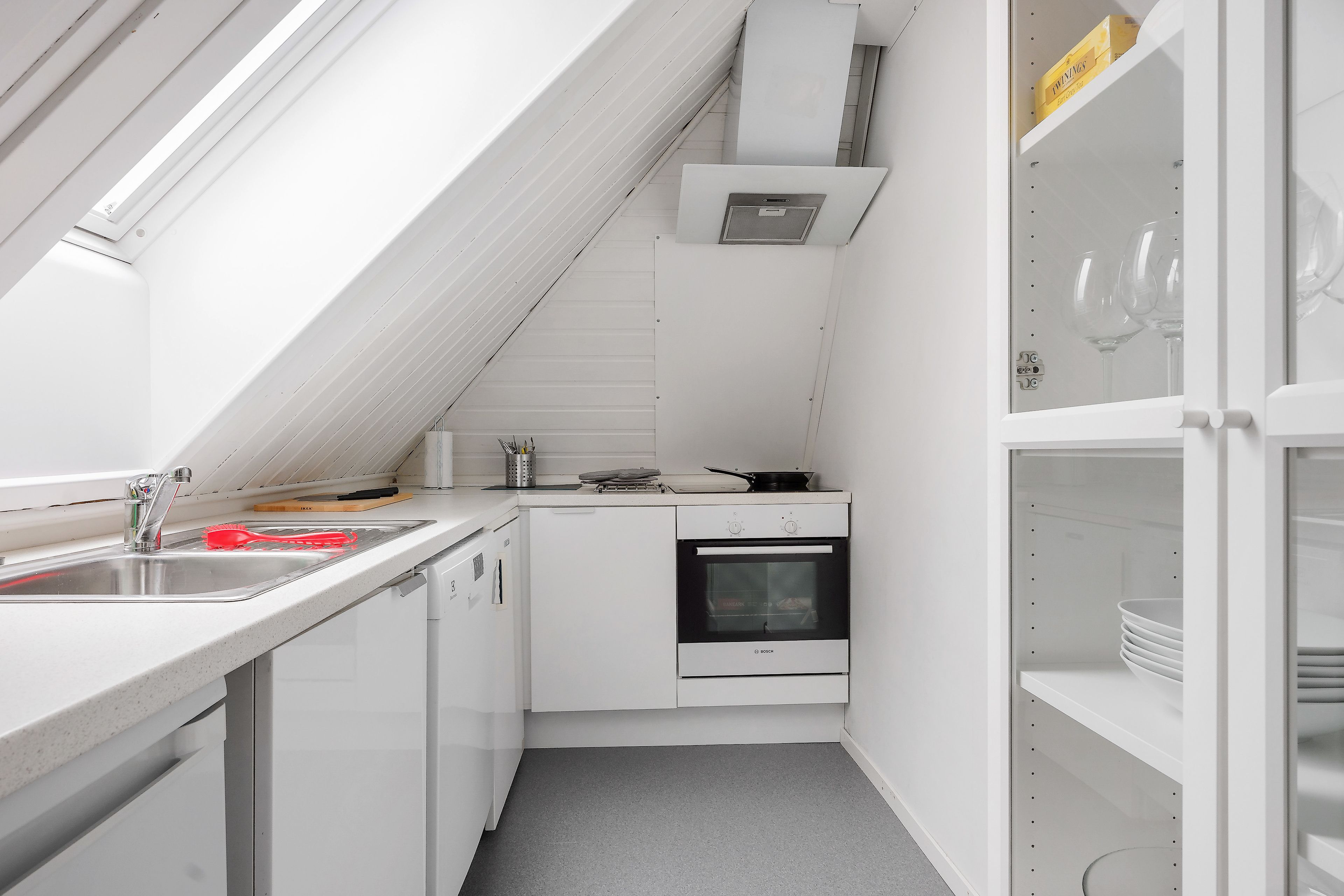 A compact kitchen with a built-in oven, a sink, and a small countertop.
