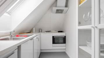 A compact kitchen with a built-in oven, a sink, and a small countertop.