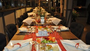 A restaurant table set with plates of food, glasses, and cutlery. - Otel Familia (Orhangazi)