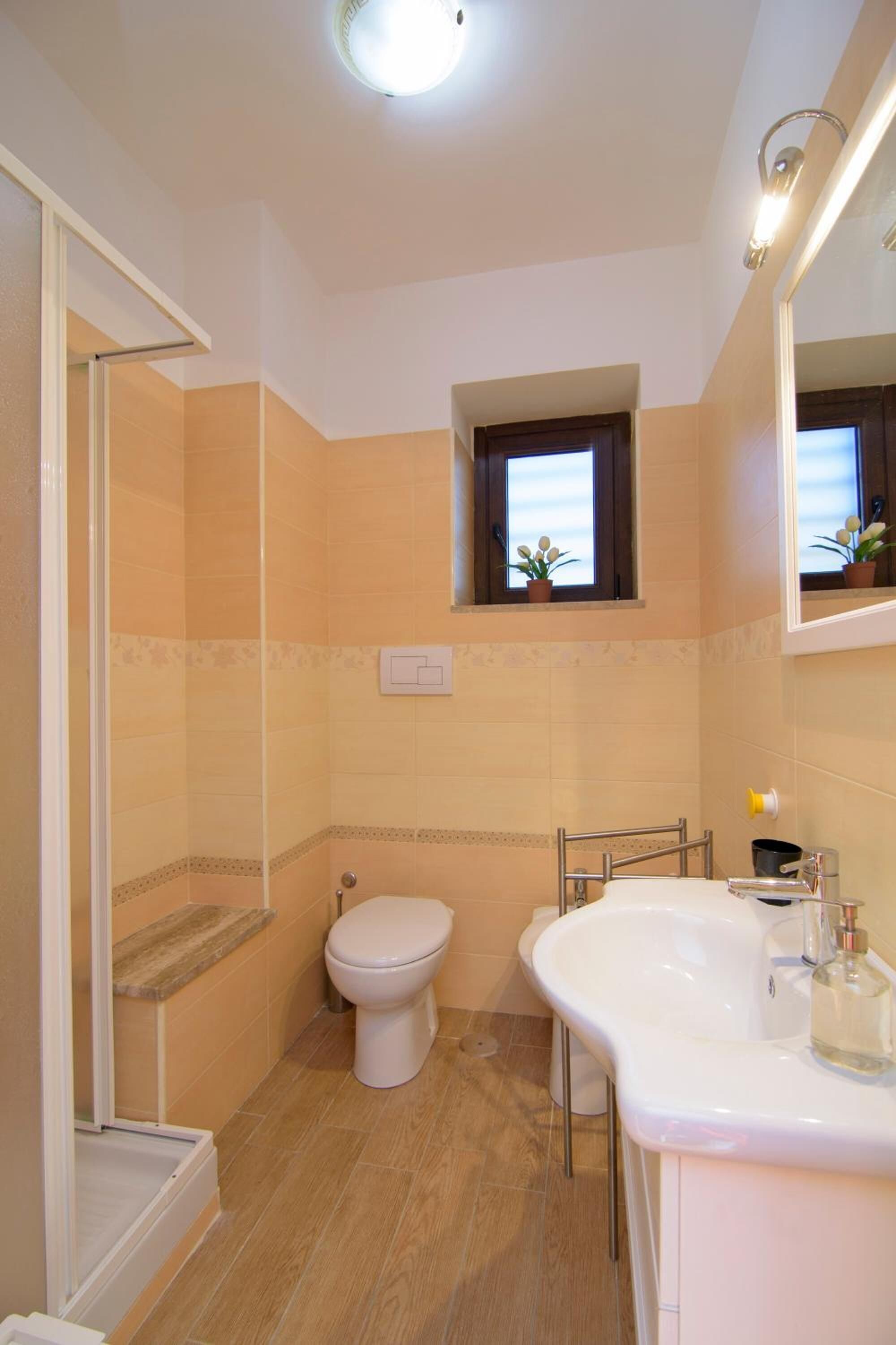 A bathroom with a toilet, sink, and shower.