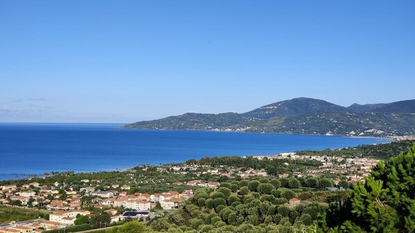 Un pueblo costero con vista al mar y colinas al fondo.