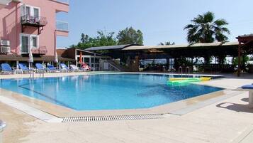 Una piscina al aire libre de temporada, sombrillas