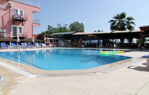 Piscine extérieure en saison, parasols