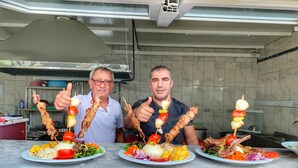 Cucina con piani in marmo, piano cottura a gas e lavello in acciaio inossidabile.
