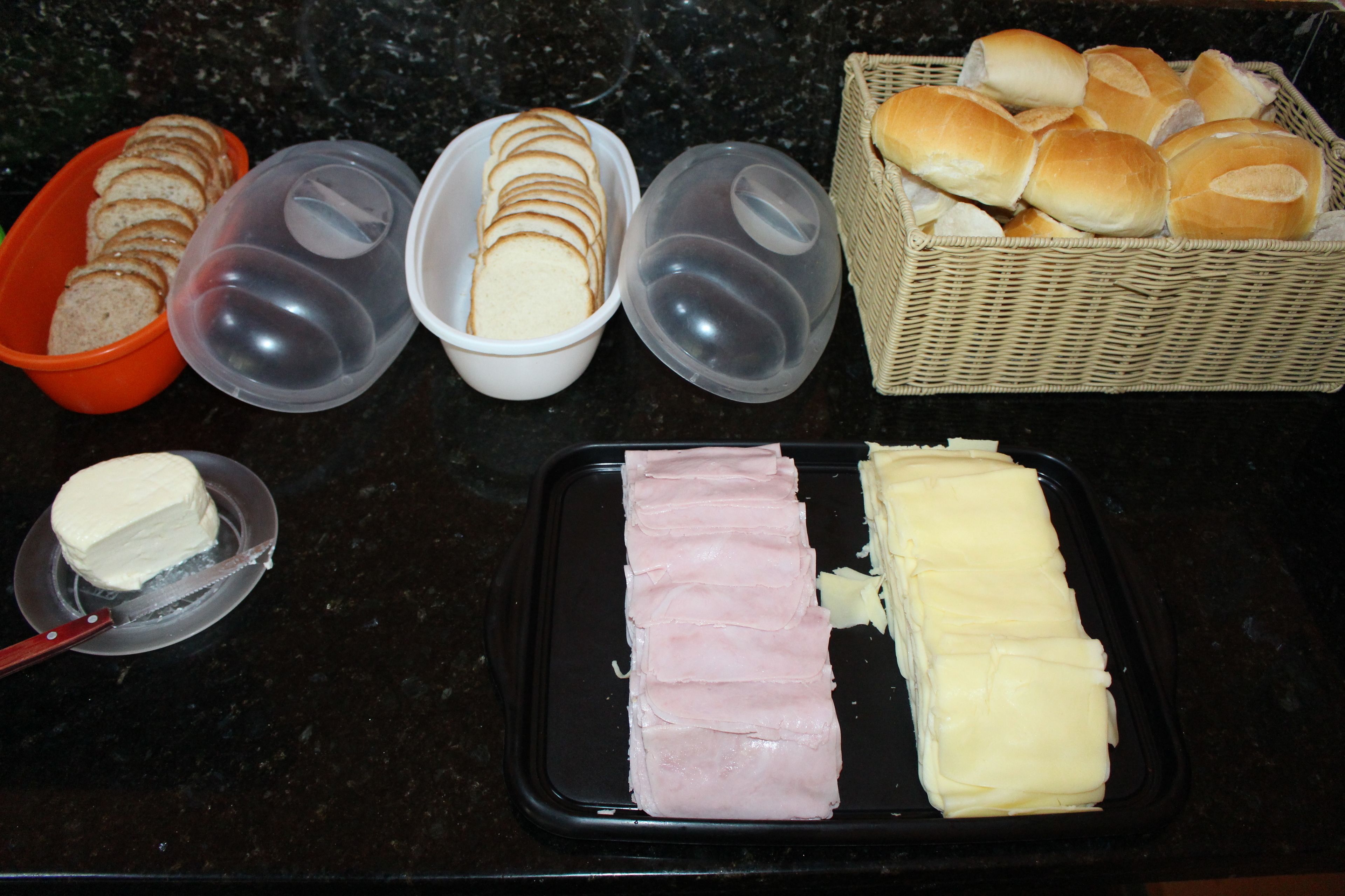 A kitchen counter with bread, butter, and ham.