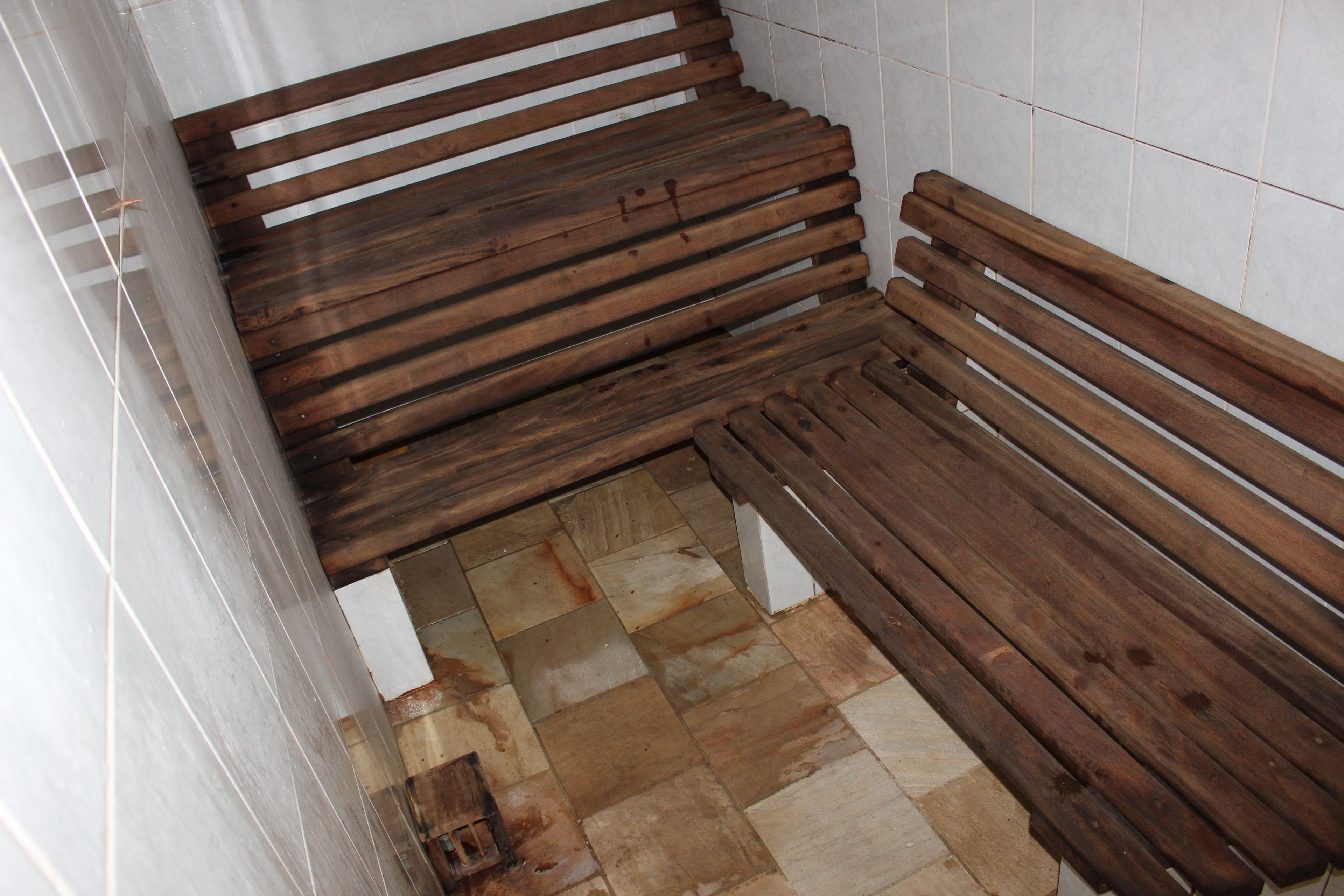 A wooden bench with a tiled floor.