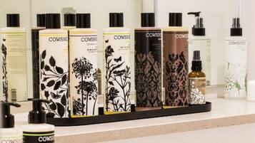 A display of Cowshed Products on a counter with a sign indicating 'HIDING SPACE'.