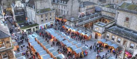 Un marché animé en plein air, avec de nombreux étals et une foule de visiteurs.