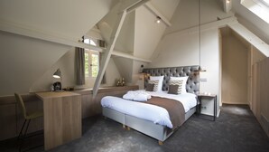 Een moderne slaapkamer met een groot bed, een bureau en een stoel.