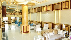 Un hall d’entrée luxueux, agrémenté d’un magnifique lustre, de fauteuils confortables et d’une décoration élégante.