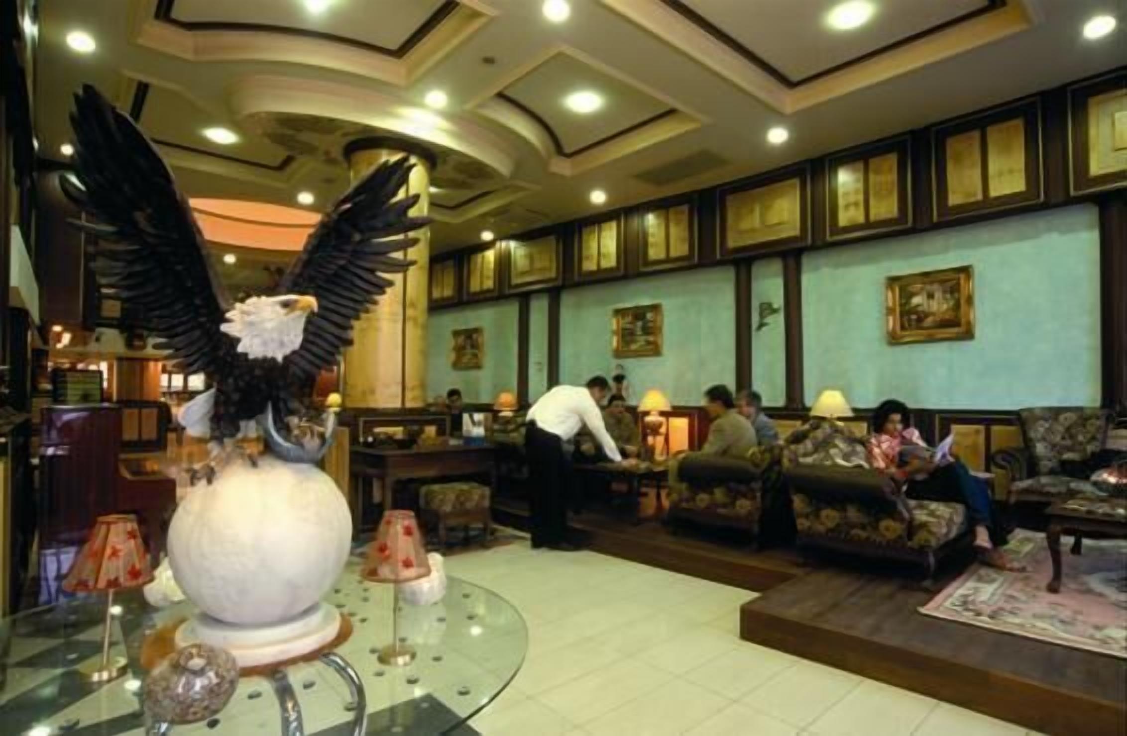 A lobby with a large eagle statue, seating areas, and framed artwork on the walls.