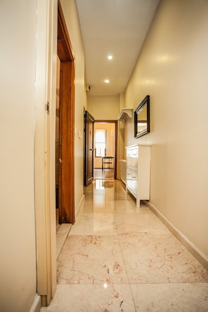 Corridors lead to a room with a white cabinet and mirror.