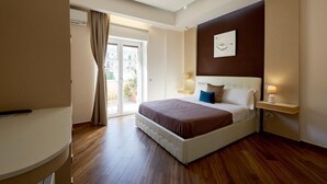 A hotel room with a bed, bedside lamps, a wall-mounted artwork, and a sliding glass door to the outside. - 360 Hospitality (Salerno)