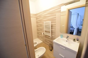 A bathroom with a modern design, featuring a white sink, a toilet, and a towel rack. - B&B Pignatelli (Matera)