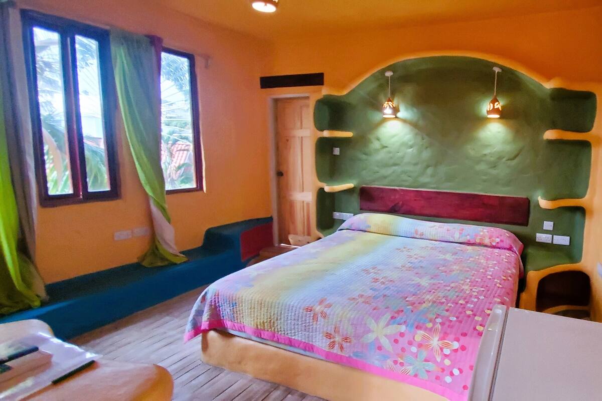 Ein Schlafzimmer mit einem Bett, einem Spiegel und einem Vorhangfenster.