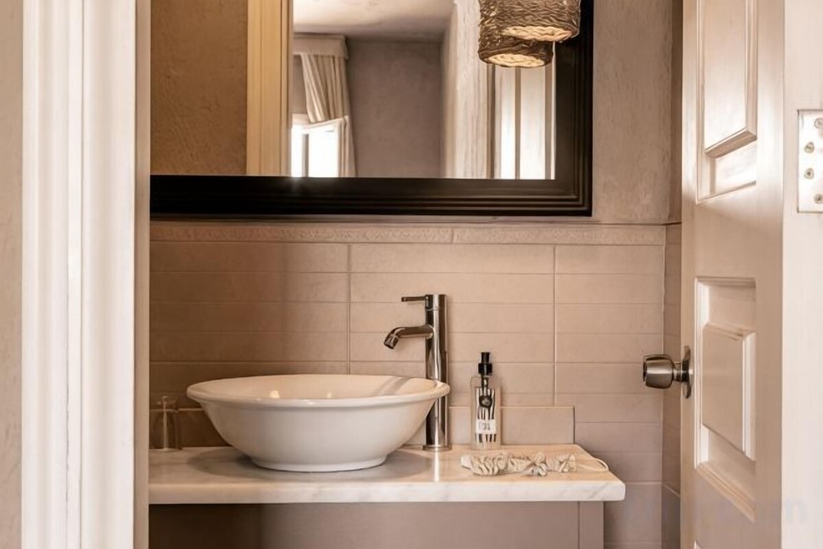 A bathroom with a white sink, a mirror, and a towel rack.