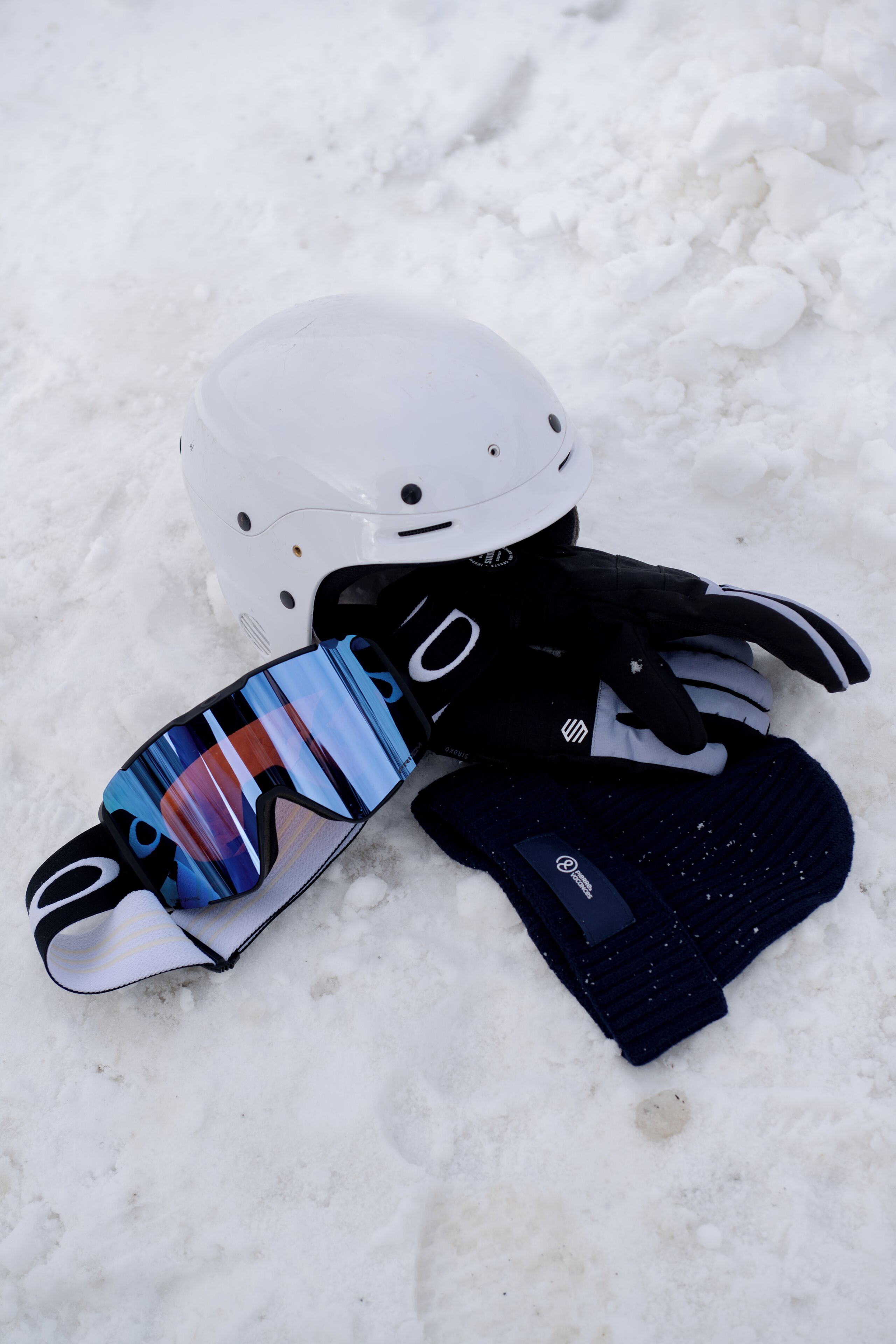A helmet and gloves on snow.