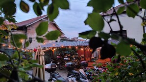A courtyard with motorcycles parked, a covered seating area, and string lights. - Pension Buon Gusto Sibiu - motorcycle friendly (Sibiu)