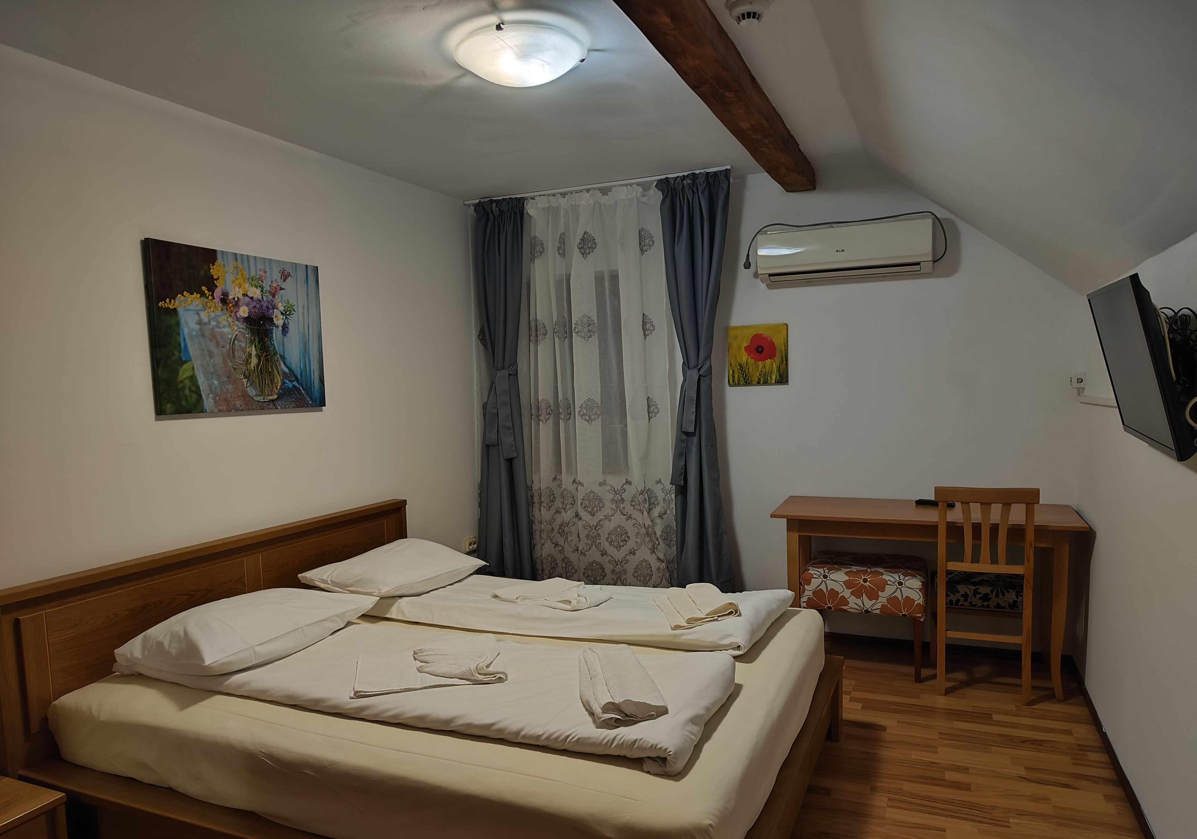 Un dormitorio con cama, escritorio y aire acondicionado.