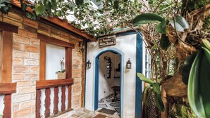 A traditional building with a brick facade, a wooden balcony, and a blue and white entrance. - Santa Smart Hotel (Ilhabela)