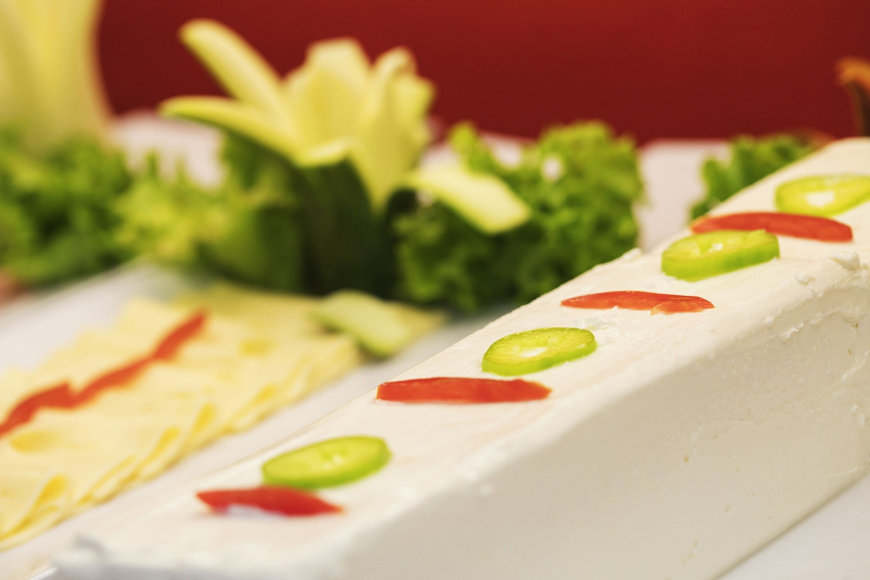 A close-up of a food item with green and red toppings.