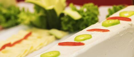 A close-up of a food item with green and red toppings.