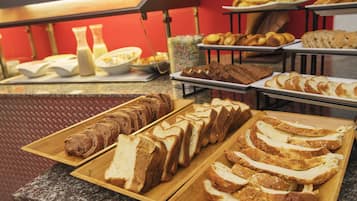 Un buffet con diversi tipi di pane e dolci.