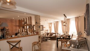 A cozy living room with a coffee bar, wooden furniture, and a fireplace. - Le Logis Aux Bulles (Verzy)