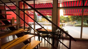 A modern interior with a staircase, wooden benches, and a view of the outdoors through large windows. - Casa D'Edite (Chamusca)