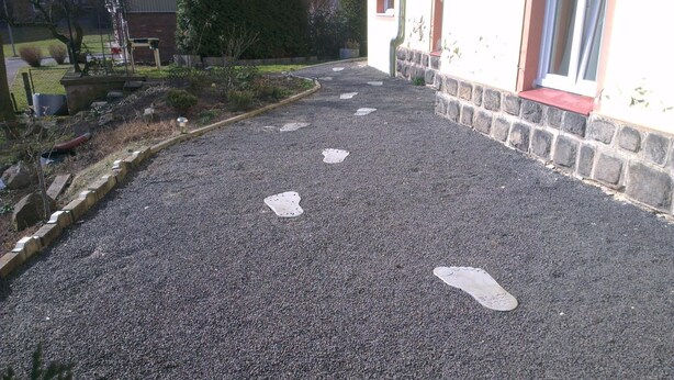 A gravel driveway with white footprints leading to a building entrance. - Pension Lada (Karlovy Vary)