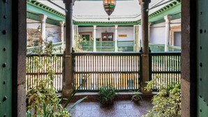 A covered outdoor area with a green roof, columns, and a railing. - Dar Hayder (Tunis)