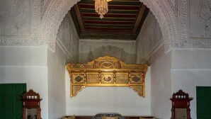 A room with a sofa, a round wooden table, and two wooden cabinets. - Dar Hayder (Tunis)