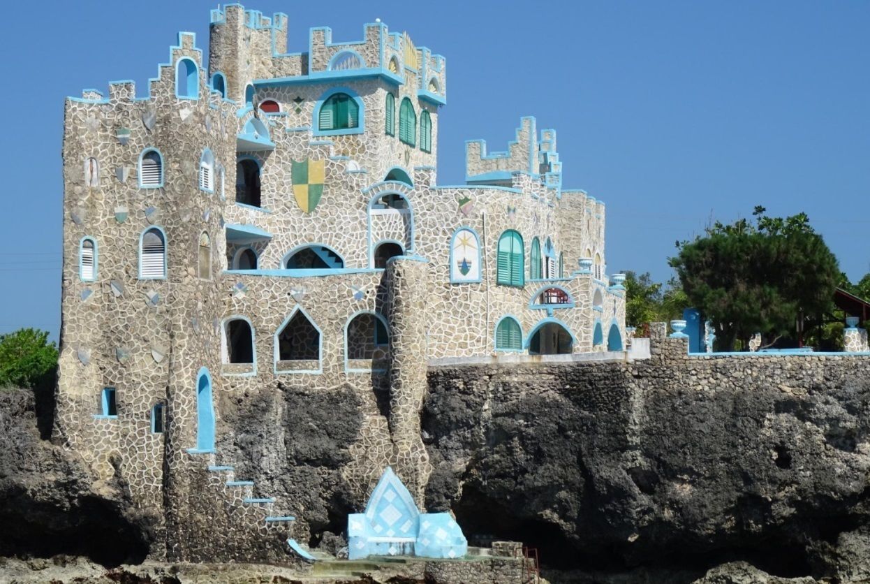 A castle-like building with multiple levels, arched windows, and a prominent tower.