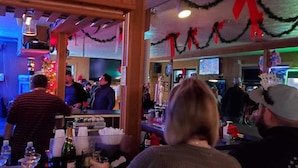 A bar with a counter, festive decorations, and a Christmas tree. - Charlie's Motel (Frostburg)