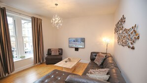 Apartamento, 2 habitaciones | Sala de estar | Una televisión de pantalla plana, un reproductor de DVD