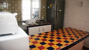 A kitchen with a patterned backsplash, a refrigerator, a sink, and a colorful checkered countertop. - Casa Moises (Mazatlán)