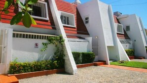 A modern building with a unique architectural design, featuring a combination of red and white colors and a sloped roof. - Casa Moises (Mazatlán)