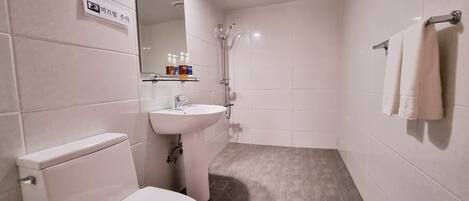Un baño moderno con inodoro, lavamanos y ducha.