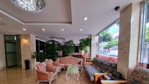 A lobby with a marble floor, a large window, and two sofas. - Hotel G (Jeju City)