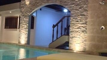 Alberca al aire libre y camastros