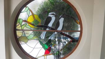 A circular stained glass window with birds and a sun.