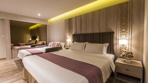 A modern hotel room with two beds, a sitting area, and a decorative wall panel. - S.D. Avenue Hotel (Bangkok)