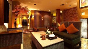 A lobby with a reception desk, seating area, and a wall with a framed picture. - S.D. Avenue Hotel (Bangkok)