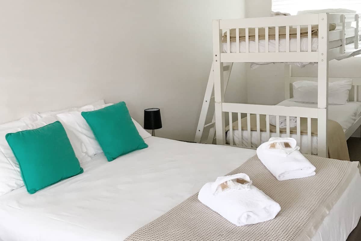 Deluxe Room (Quadruple) | Peralatan tempat tidur premium, meja, ruang kerja komputer riba