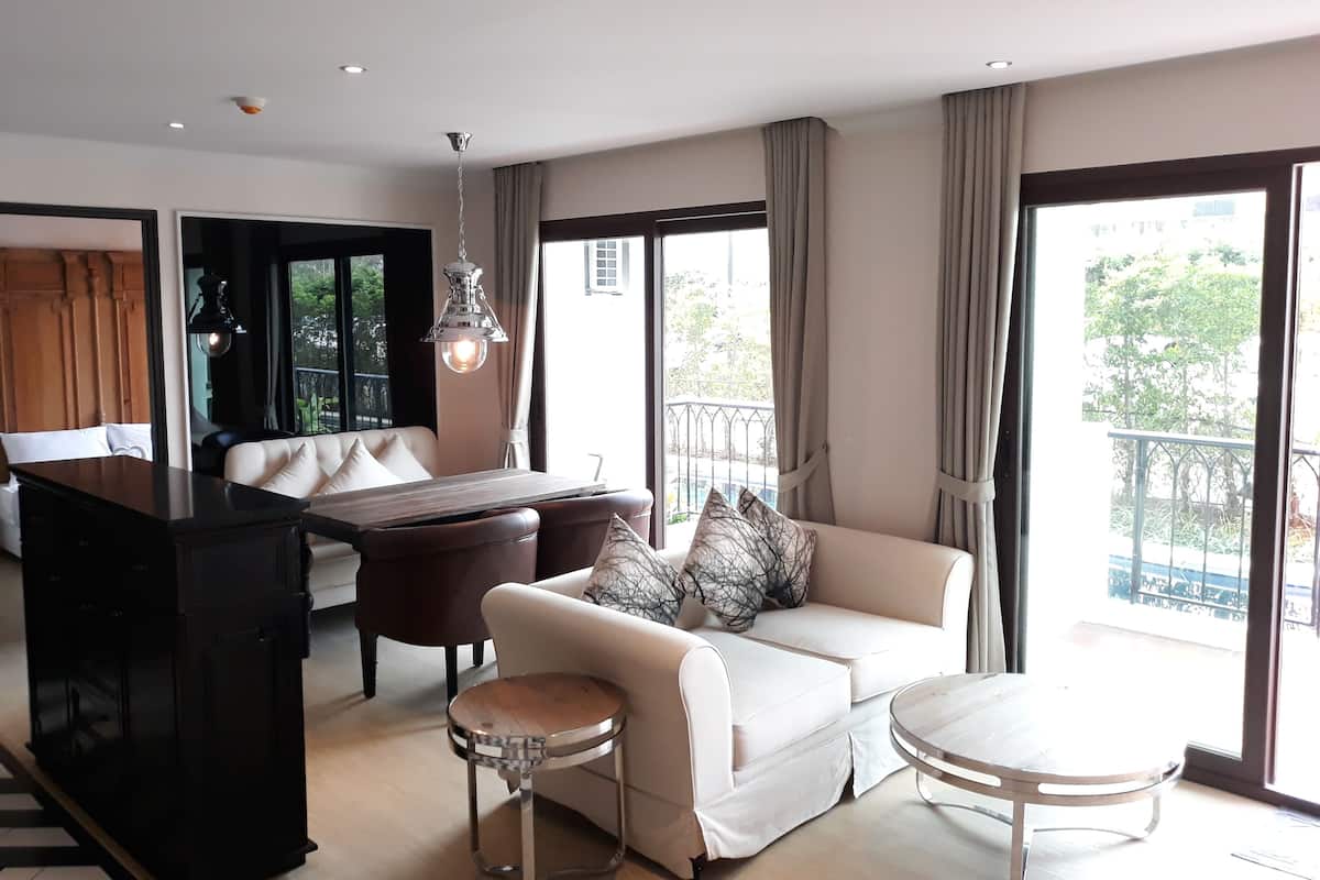 Ein modernes Wohnzimmer mit Sofa, Couchtisch, Esstisch und einem Klavier.