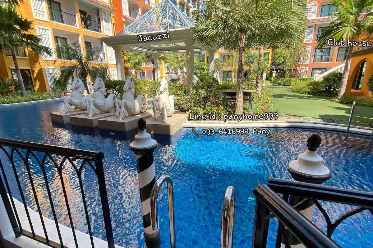 Ein Swimmingpool mit einem Gazebo, auf dem „Jacuzzi“ steht, und einer Statue eines Pferdes.