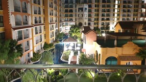 Un hôtel à plusieurs étages doté de balcons, d’une cour intérieure et d’un espace piscine.